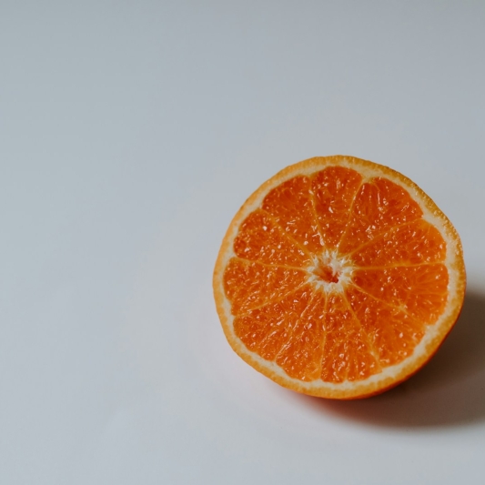 sliced orange fruit on white surface